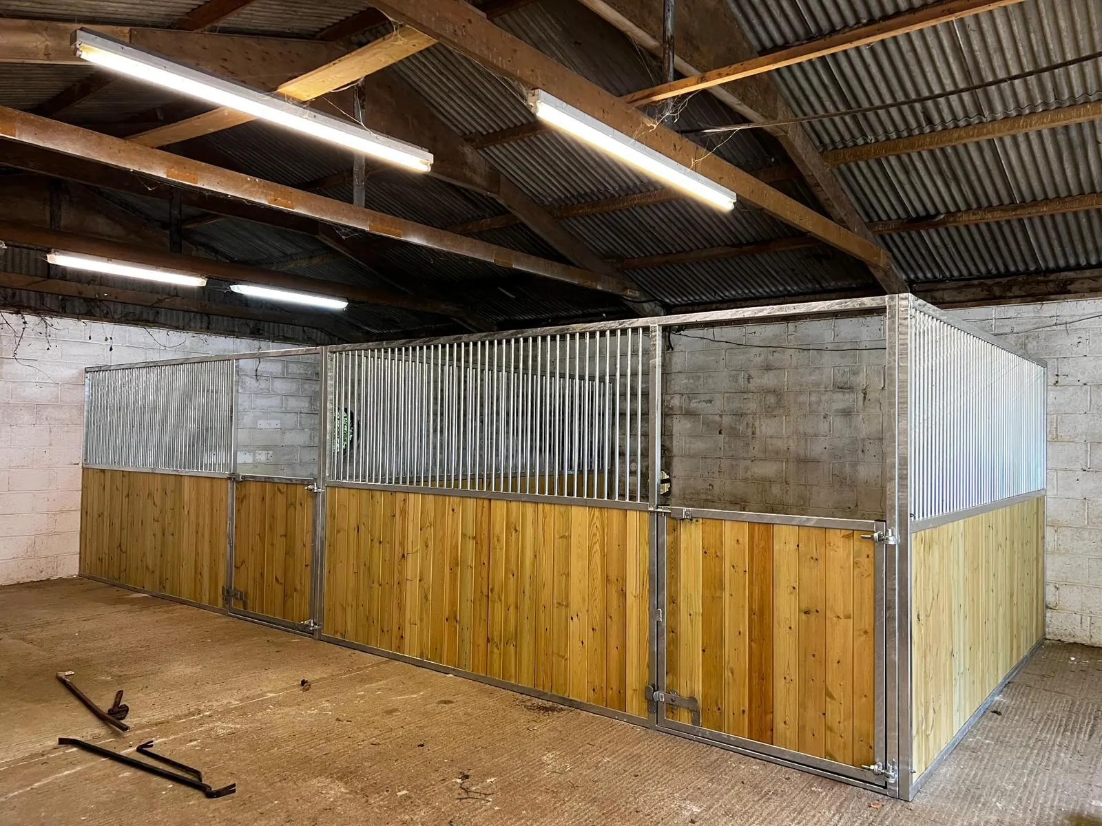 Internal stable row with natural timber panels and metal bars