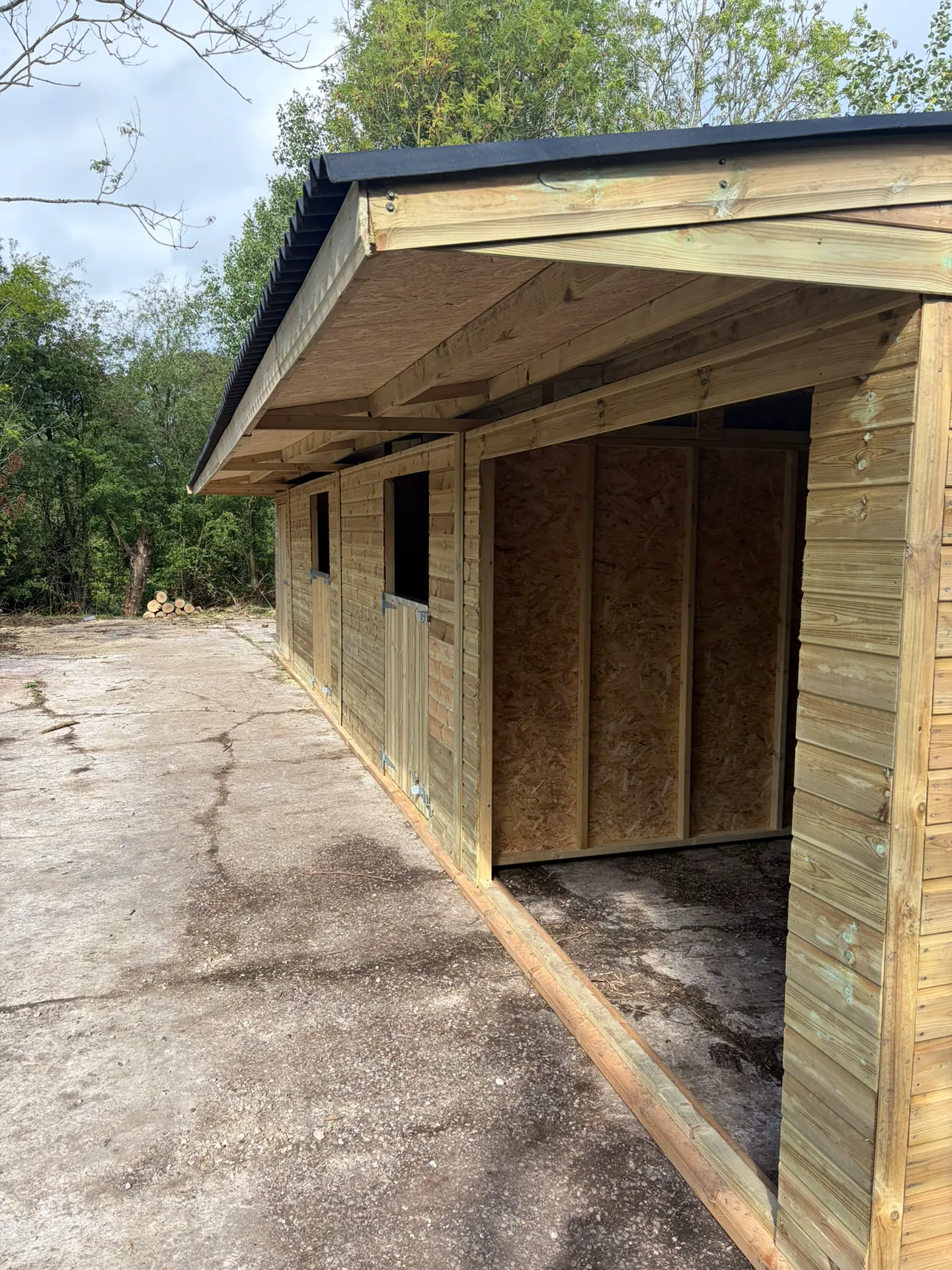 Close view of timber cladding and a wide roof overhang on a stable building